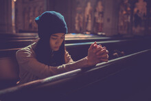 Young Woman Prayer's Pray Alone In Church, People Pray To God With Folded Hands, Old Wooden Classic Long Chairs Background