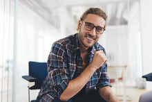 Portrait Of Happy Hipster Guy In Optical Eyewear For Provide Vision Correction Smiling At Camera In Coworking Space, Cheerful Caucaisan Man In Glasses Dressed In Smart Casual Shirt Posing Indoors