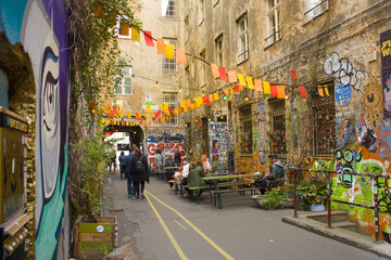 Haus Schwarzenberg - Street Art Alley with narrow passage next to a cafe leads to a courtyard exploding with murals in Berlin, Germany