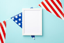 USA Independence Day Concept. Top View Photo Of Photo Frame And National Flag Garland On Isolated Pastel Blue Background With Empty Space