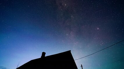 Wall Mural - starry sky turning space with milky way above old country house, astrophotography time lapse