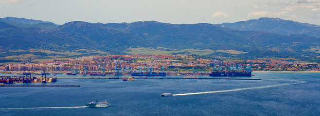 Panoramic view of the industrial port of Algésiras in the south of Spain - Giant cranes loading containers onto maritime freighters in the Mediterranean Sea