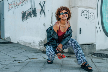 young afro american girl in urban style in summer on the city street