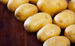 Raw potato tubers on a wooden table. High quality photo