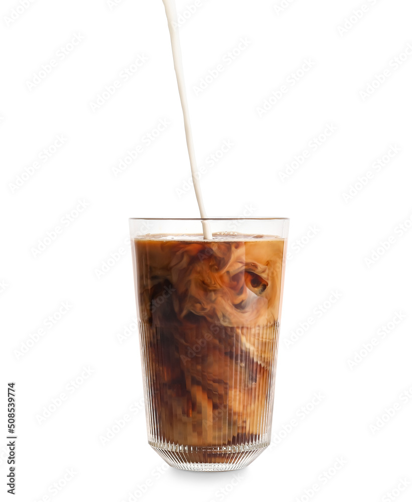 Pouring of milk into glass with iced coffee on white background