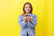 happy asian woman standing while holding something with palms