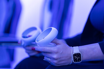 female hands playing with virtual reality controller and wearing a smartwatch