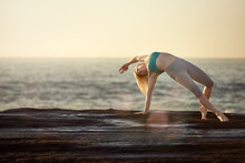 Woman Doing Yoga By The Ocean