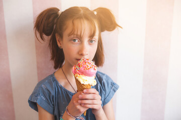 Wall Mural - Cute little girl eating ice cream in cafeteria. Child holding icecream. Kid and sweets