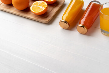 Wall Mural - Fresh orange juice in the glass with orange fruit on wooden background