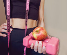 Slim Unrecognizable Woman With Tape Measure And Apple In The Hand  .Weight Loss And Healthy Lifestyle Concept
