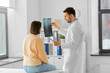 © Syda Productions - medicine, healthcare and people concept - male doctor showing x-ray to female patient at medical office in hospital