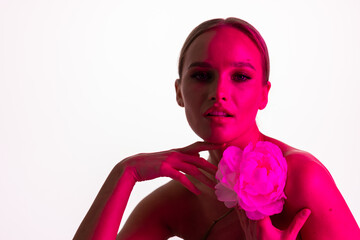 Wall Mural - Beautiful young woman with white flower on pink neon light background