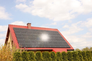 Wall Mural - House with installed solar panels on roof. Alternative energy