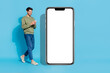 © deagreez - Full body portrait of positive person use telephone walk empty space blank isolated on blue color background