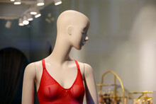 Female Mannequin In Red Bra, View Throw The Glass. Sexy Underwear In Window Of Lingerie Store
