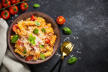 Canvas Print - Italian pasta alla arrabiata with basil and parmesan on dark table. Top view image with space for design.