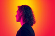 © master1305 - Back view of serious man with long curly hair posing isolated on gradient yellow-magenta background in neon. Concept of beauty, fashion, youth culture and emotions