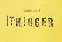 Trigger Warning Sign Message On Yellow Background. Stamp Letters Mental Triggering Concept.