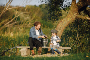 Wall Mural - Young father teaching his little toddler son how to fish