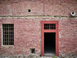 Facade of a brick house with a door and a barred window in an old fortress in Komarno, Slovakia
