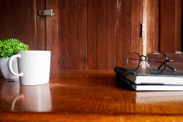 Fototapete - Cropped shot view of wood office desk table with the cup of coffee,office equipments, and other office supplies on the modern space, flat lay.
