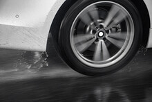 Detail Of The Rear Wheel Of A Car Driving In The Rain On A Wet Road. Aquaplaning In Road Traffic.