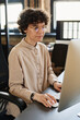 © pressmaster - Office employee in eyeglasses sitting at her workplace at office and working on computer using mouse and key