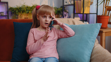 portrait of caucasian little happy child girl enjoying conversation on mobile phone with friend rela