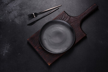 An empty plate with a knife, fork or spoon with a wooden cutting board