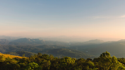 Canvas Print - Cardamom hills under clear sky with mist on horizon at sunset in Thekkady, India.