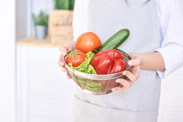 Young girl cooking at kitchen with vegetables. pretty child portrait. Chef student. Attractive brunette. Children emotion. People baking in cook apron. Close recipe menu