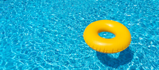 Wall Mural - Yellow inflatable ring floating in swimming pool. Vacation concept with copy space