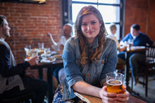 Young Woman Holding A Glass Of Beer