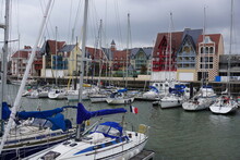 Sailboats In The Harbor By Colorful Buildings In Normandy, France