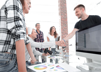 Poster - handshake of colleagues in a creative office.