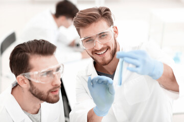 Wall Mural - two biologist examining liquid in a test tube