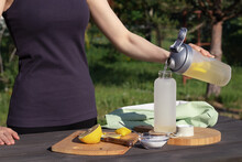 Girl Makes A Fresh Homemade Isotonic Drink From Natural Ingredients - Salt, Lemon And Mineral Water