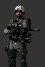 Photo Of Isolated On Grey Black Soldier Dressed In Protective Uniform Posing With Rifle.