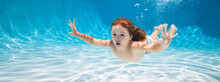 Happy Kid Swims In Pool Underwater, Active Kid Swimming Under Water, Playing And Having Fun, Children Water Sport. Summer Holiday With Children.