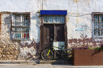 Wall Mural - Facade of the old brick house in the old town of Antalya, Turkey. Modern bicycle parked against a wooden door.