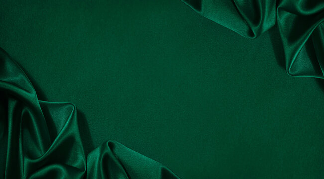 Wall Mural -  - Dark green silk satin background. Wavy folds. Smooth surface. Shiny fabric. Luxury background with copy space for design. Web banner. Top view table. Flat lay. Wide.