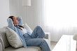 © Evrymmnt - Portrait of young beautiful woman with long straight brunette hair sitting on the couch, relaxing and enjoying her alone time. Brown eyed female in a relaxed position. Copy space, background, close up