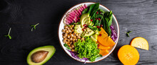 Fresh Salad With Roasted Chickpeas, Avocado, Persimmon, Spinach, Avocado, Watermelon Radish And Seeds On A Dark Background. Long Banner Format. Top View