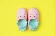 Pink Kids Clogs Beach Slippers On Yellow Background. Summer Vacation Concept. Fashion Sandals Beach Flip-Flops