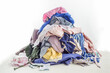 © smirart - Used clothes in a pile. Sorting and cleaning second-hand. Preparing for washing. Copy space on white background