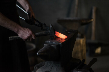 blacksmith hitting a red-hot iron with a hammer