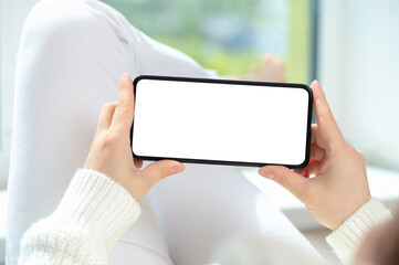 Poster - Woman lies in relaxed position and watches video content on cellphone or mobile smartphone. holding phone horizontally