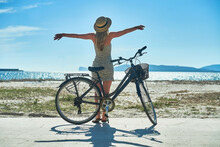 Carefree Woman With Bike Riding On Sand Beach Having Fun, On The Seaside Promenade On A Summer Day.