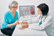 Doctor cardiologist analyzes heart electrocardiogram results of senior female while consultation. Diagnosis of heart rate and heart disease of older people